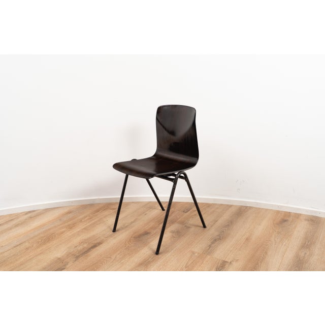 Model S25 by Galvanitas. The chair comes with a dark wooden seating and backpiece on a black coated metal frame. This...