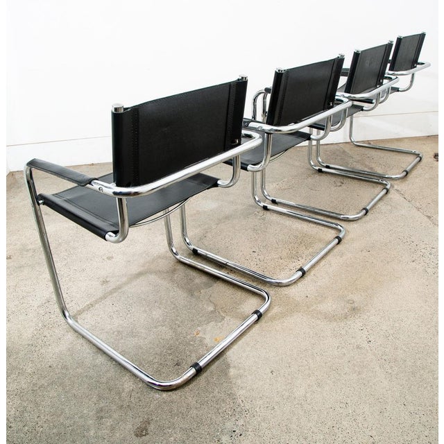 Set of 4 stylish black saddle leather Italian made armchairs. Stamped "Made in Italy" on the side of each chair. Unknown...