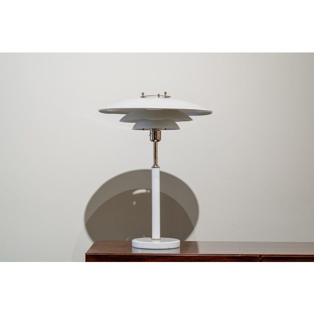 Danish table lamp in off-white metal with a triple shade and a single light inside. The switch is located under the shade....