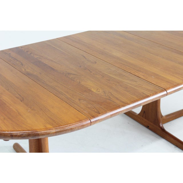 Vintage Danish round extendable dining table from the 1960s made of solid teak wood. This Danish dining table can be...