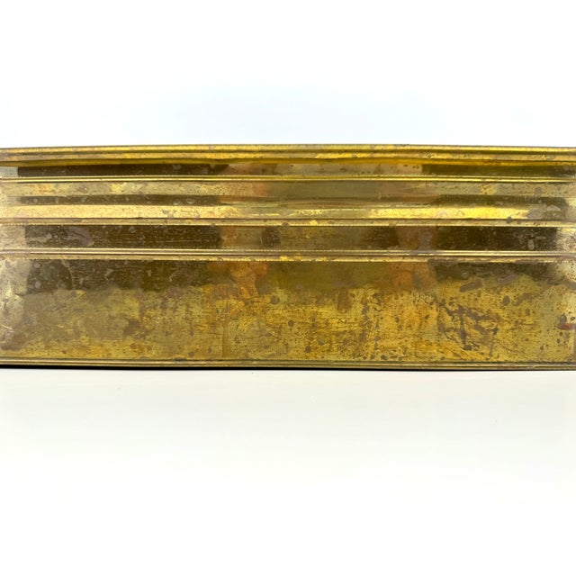 A substantial vintage brass jardinière featuring an elongated oval form, rolled rim and handsome horizontal ribbed...