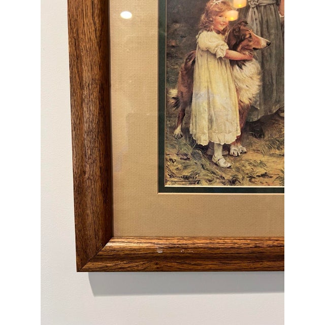 Vintage framed print after Arthur John Elsley’s 1908 painting A Tempting Bait, depicting four children enticing a white...