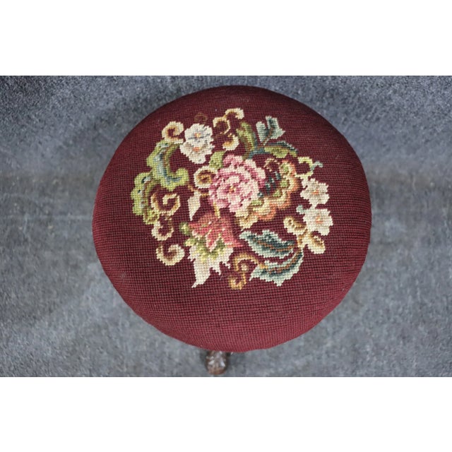 Adjustable carved Walnut stool with floral needlepoint upholstery.