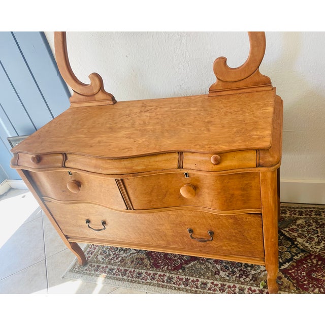 Beautiful late Victorian-era dresser and mirror, featuring a warm honey-toned wood finish, graceful serpentine-shaped...