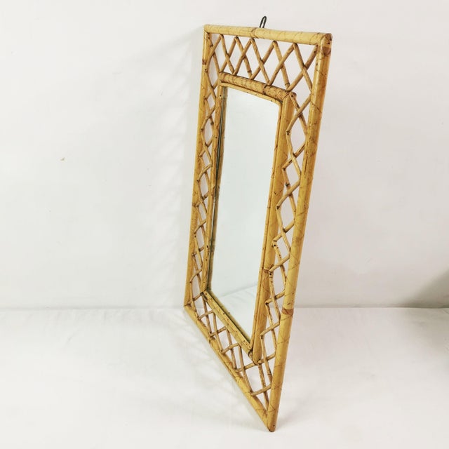 Wall mirror from Italy, 1960s. Made of bamboo and rattan. Includes a hanging loop. Geometric, decorative design....