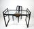 A very well-crafted ebony toned sculptural wooden desk with glass top and matching chair with the seat in a tight woven...