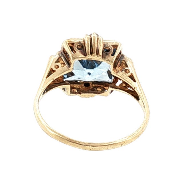 A mid-century 10k gold fashion ring featuring a synthetic blue spinel with a fantasy princess cut. The design includes...