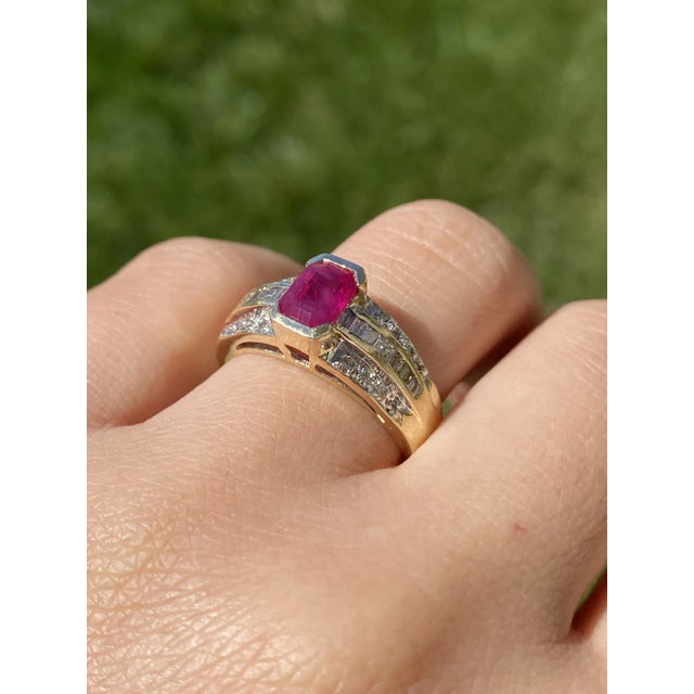 The Red Bay: Yellow Gold Ring set with Emerald Cut Lab Grown Ruby and Diamonds. The ring features a central 1.52 carat...