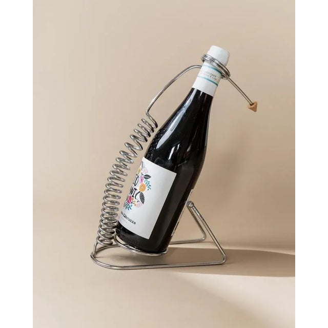 This vintage steel bottle holder in a spiral space age design with a small brass tip from the 1980s is an elegant table...