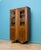 A well-made 1930s oak display cabinet with classic Art Deco styling. Featuring glazed doors with carved detailing, fluted...