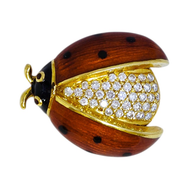 Vintage 18K yellow gold brooch in a ladybug design. The body is encrusted with diamonds and the wings are decorated with...