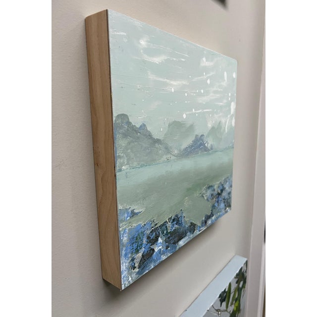 Abstract waterscape with distant mountains in blue and aqua