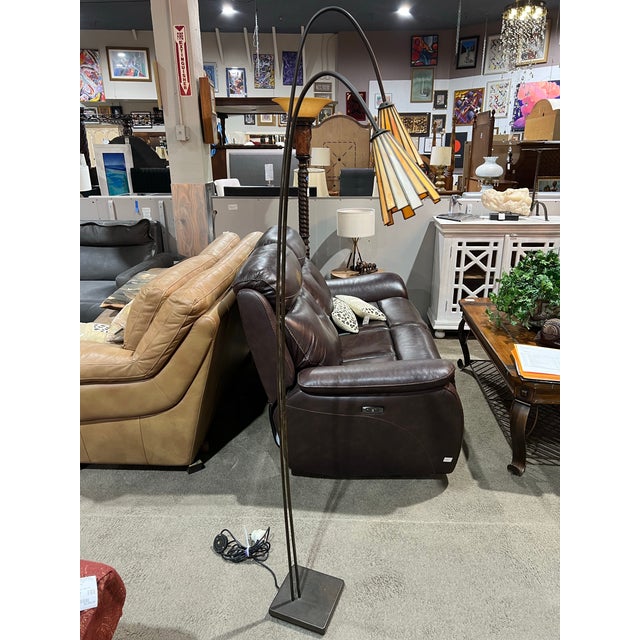 This black iron and stained glass floor lamp is a beautifully sculptural lighting piece that blends classic craftsmanship...
