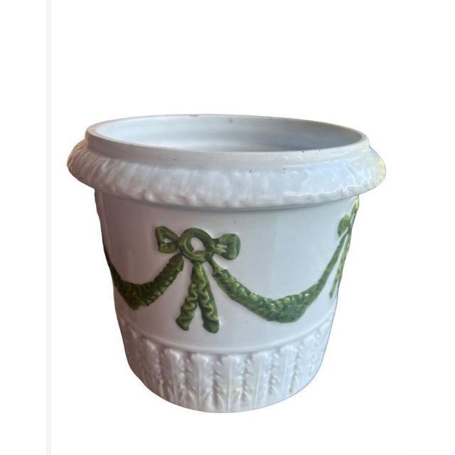 This heavy planter is perfect for a sunroom or sunny spot in the home. The draping garland design is graceful and timeless.