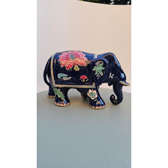 Vintage 1980s glazed ceramic elephant figurine with floral motifs, dimensions: height 13 cm, width 22 cm, depth 9 cm.