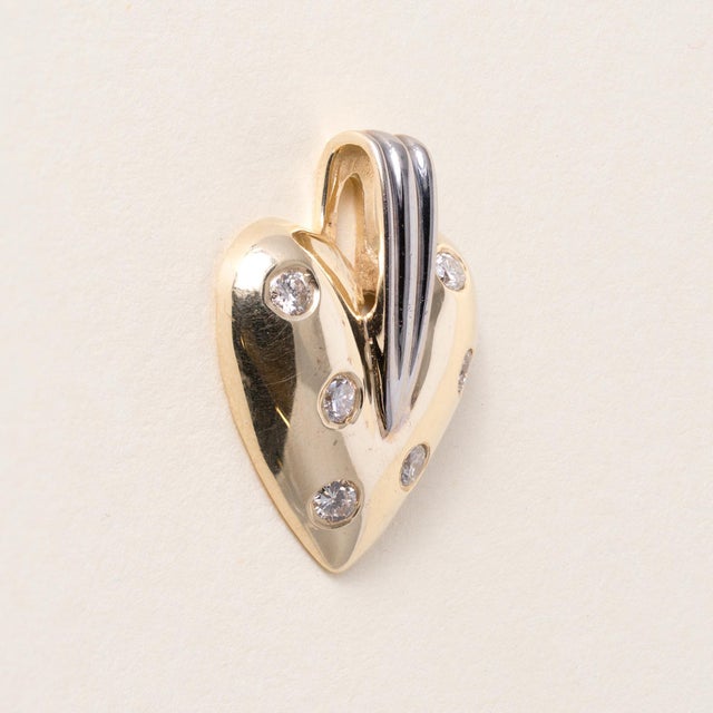 Vintage Two-Tone Gold Diamond Puffed Heart Pendant Circa 1990 This vintage pendant is crafted in two-tone solid 14K gold...