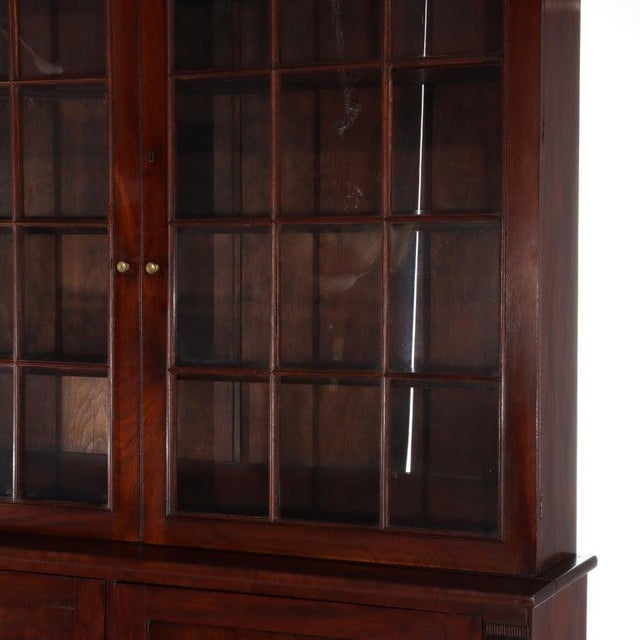 Presenting an exceptional antique Sheraton style step-back display cabinet, meticulously crafted from rich flame mahogany...