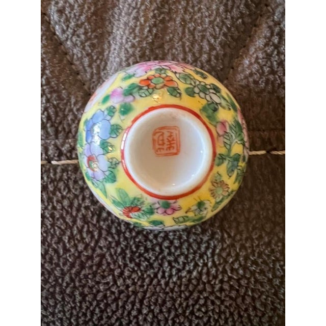 These pieces are small decorative bowls featuring the classic Famille Rose enamel palette with a vibrant yellow background...