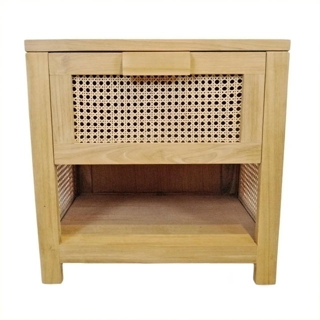 Teak wood nightstand with one drawer. Rattan cane panels on drawer and sides. Open shelving area at bottom for added...