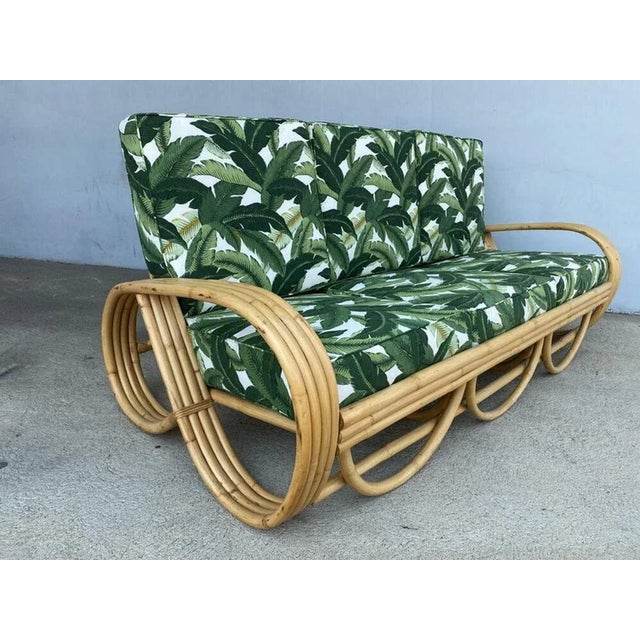 Four-strand 3/4 reverse pretzel rattan sofa featuring a decorative scalloped detail on the base. Dimensions: 28" tall x...