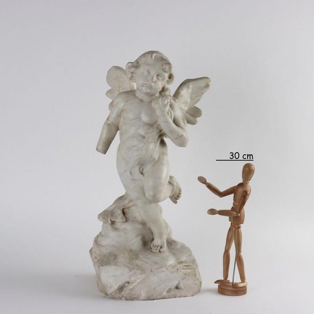 White marble sculpture depicting little angel. This piece is attributed to the mentioned designer/maker. It has no...