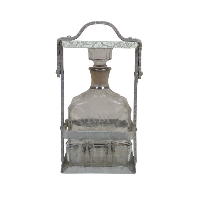 Antique Art Nouveau Tantalus decanter set featuring six shot glasses and an embossed lockable metal case with handle. The...