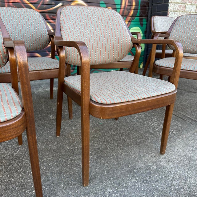 This is a set of 8 Don Pettit for Knoll office armchairs. They feature a teal and red striped fabric.