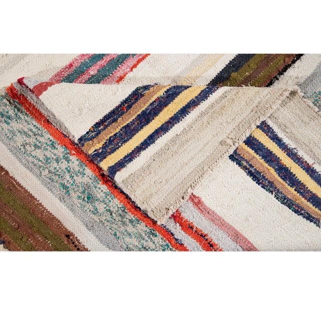 Beautiful Vintage Kilim Hand-knotted Wool rug with an Ivory field. This piece has multicolored stripes. This rug measures...