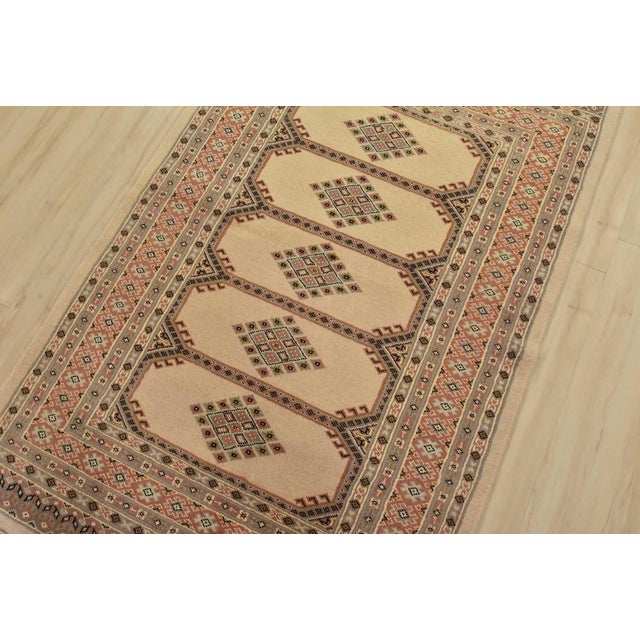 A tribal Bokhara Jaldar rug hand-knotted with fine wool on a cotton foundation. This rug features geometric medallions set...