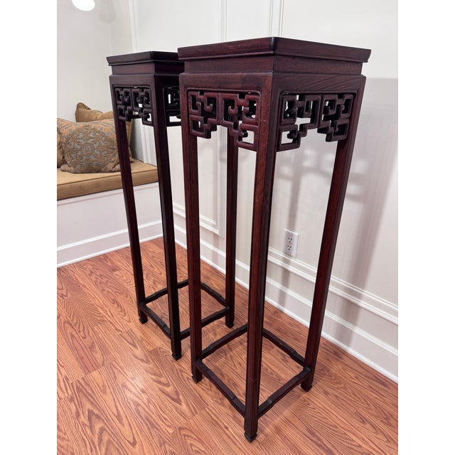 This vintage pair of monumental size Asian solid rosewood plant stands/pedestals feature traditional Ming-style aesthetics...