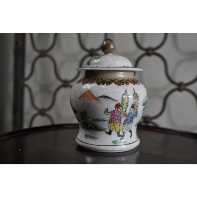 A charming vintage porcelain ginger jar featuring hand-painted figural and landscape scenes in the chinoiserie style....