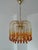 Elegant 1970s Murano glass chandelier attributed to Paolo Venini. The brass structure features cascading amber teardrop...