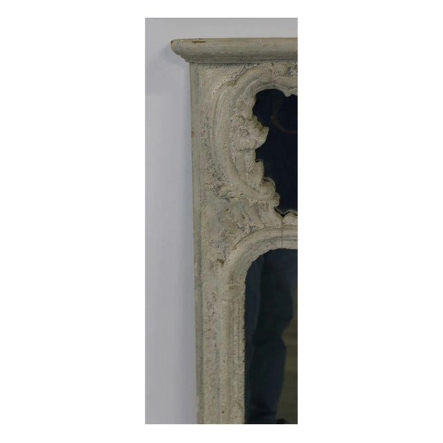 A vintage rectangular Louis XV style mirror in a distressed painted white finish. The frame features a gently curving,...