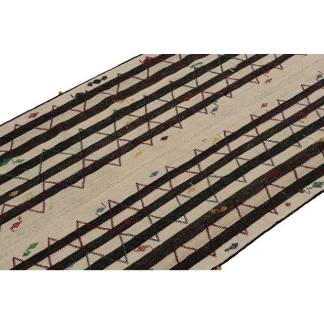 This vintage 4x8 Persian kilim is handwoven in wool, and originates circa 1950-1960. On the Design: This panel style...
