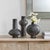 This Striking Trio Of Ceramic Vases Features A Distressed Black Finish With Subtle Dark Bronze Undertones, Giving Each...