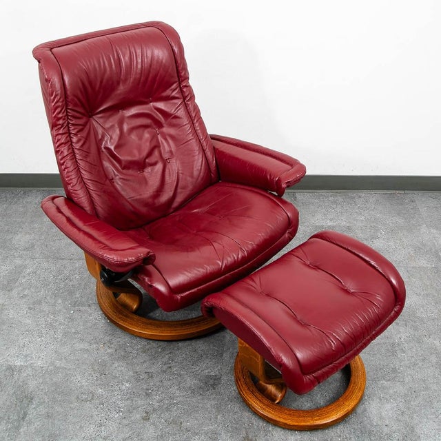 Red leather Stressless lounge chair and ottoman by Ekornes. This piece was designed and constructed in Norway. A classic...