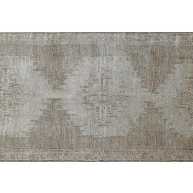 A wonderful vintage hand-knotted Turkish Oushak runner with three large medallions woven with stylized floral and vine...