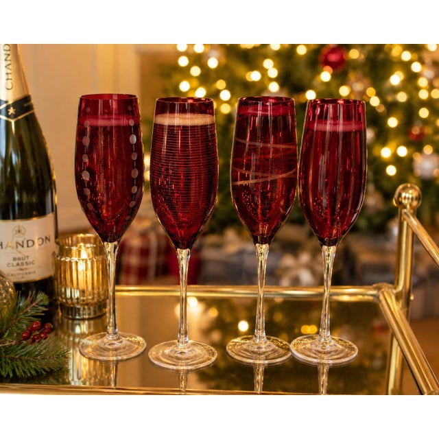 Elegant set of four Mikasa ruby red champagne flutes featuring coordinating etched designs and tall clear stems. Each...