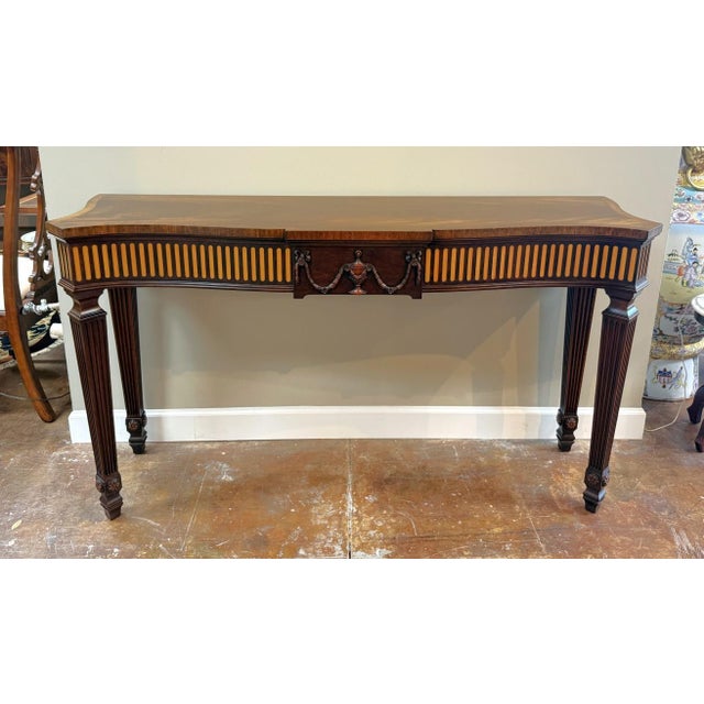 This Henkel Harris Flamed Mahogany Adams Style Console Table Model No. 5758 features a graceful bowed front, richly...