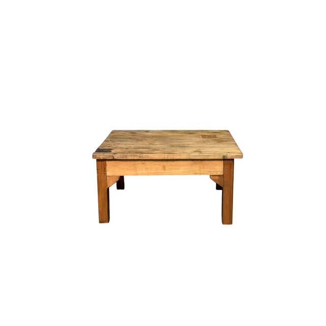 A low coffee table made of light fir wood, dating back to 1900, with a simple, rustic style. The sturdy, linear structure...