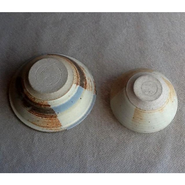 This pretty pair of studio art pottery bowls in 2 different sizes complement each other's natural earthy shades of brown...