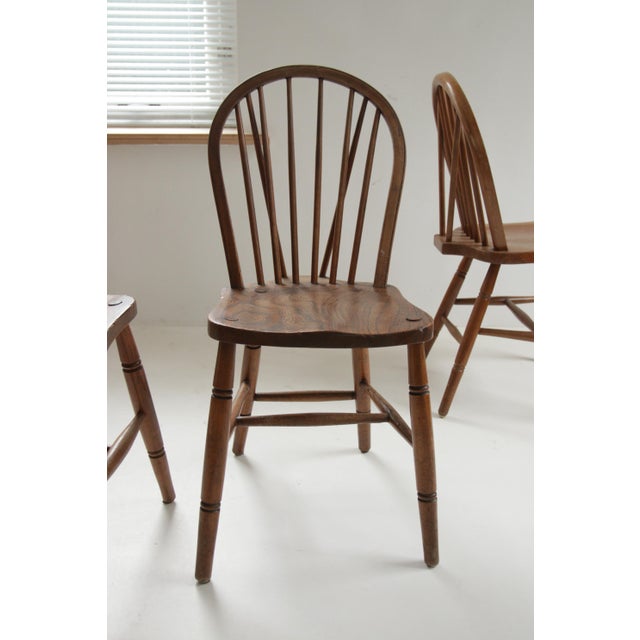 Set of four late 19th-century English hoop-back Windsor chairs with solid elm seats, each showing a rich, hand-worn patina...