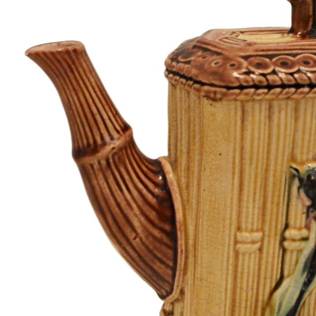 A Victorian Majolica teapot, circa 1890, featuring classic Aesthetic Movement faux-bamboo detailing. The body is styled as...