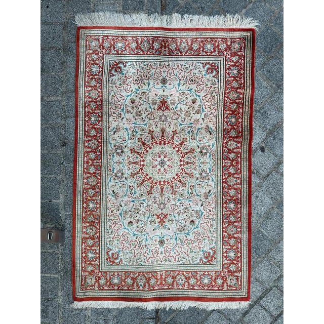 Pretty little silk Qom rug entirely and finely hand knotted with silk velvet on silk foundation. Discover the timeless...