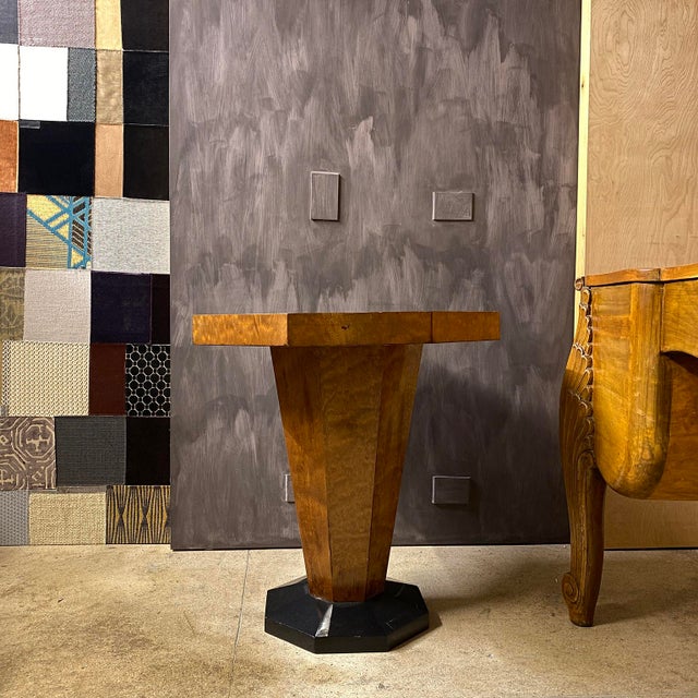 An octagonal art deco center table in walnut and ebonized base.