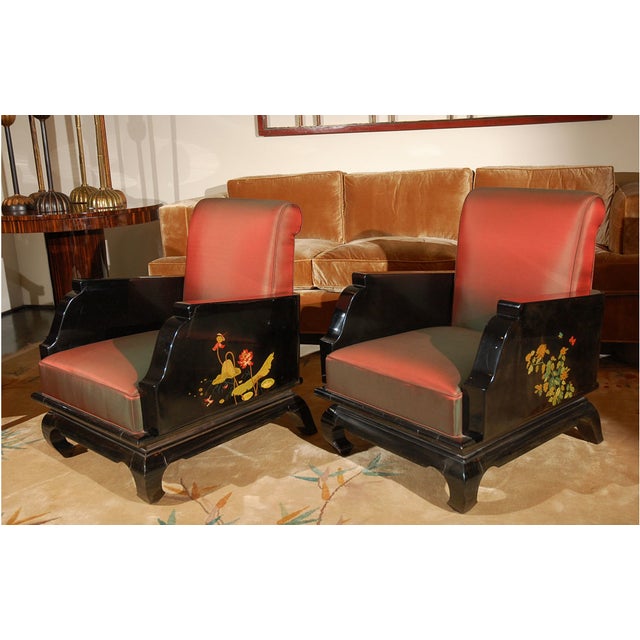 Black lacquer salon chairs with chinoiserie hand painted floral motifs on arms. One chair decorated with lotus blossoms...