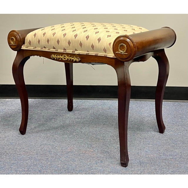 Antique turn of the century French bench. Crafted in mahogany with brass ormolu decoration. Features rolled cylindrical...