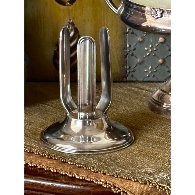 This early 20th-century silver-plated caddy was engineered to hold round-bottom 'torpedo' soda bottles upright during...