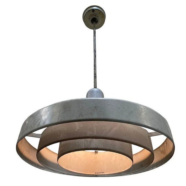 Kurt Versen designed "Saturn" ceiling light featuring a stacked steel ring light shade suspended by wire to a focused...