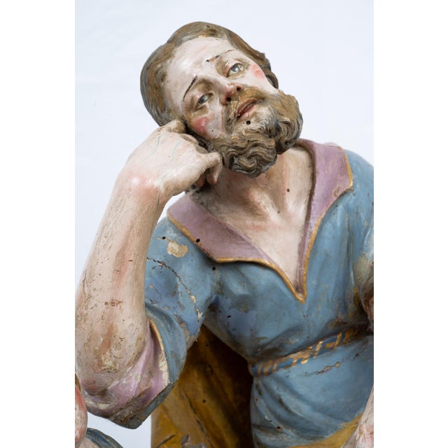Antique Neapolitan polychrome wooden sculpture depicting Saint Joseph with the Child, dating from the 18th century. The...